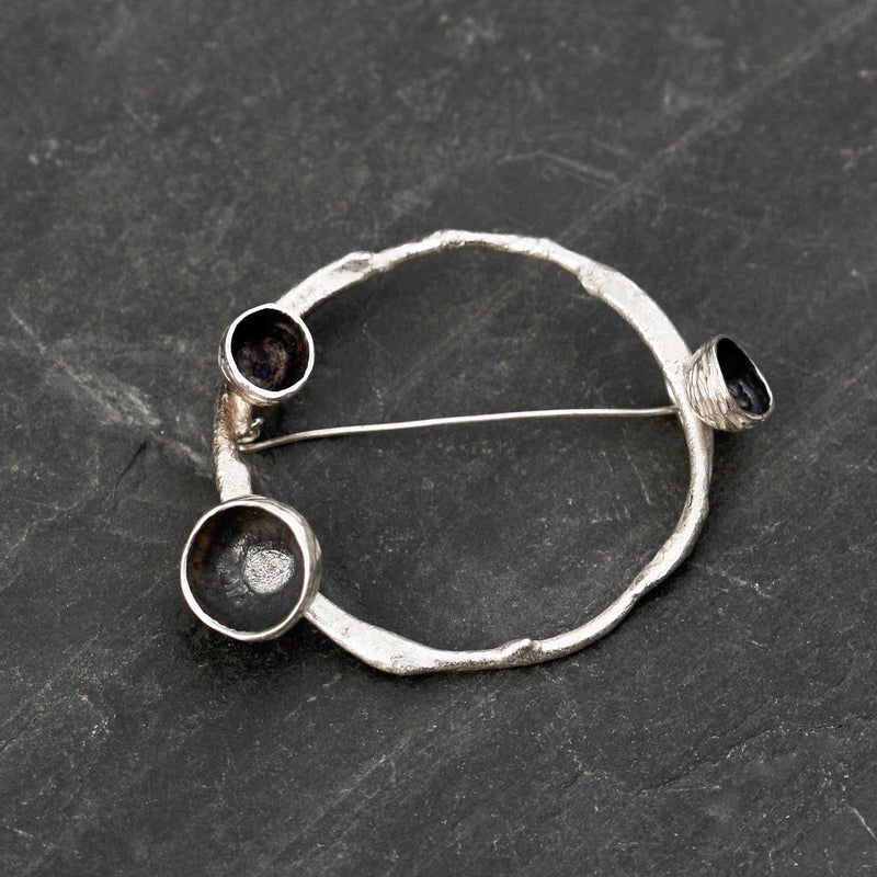 A handmade Sterling silver acorn brooch, inspired by the beauty of acorn cups on a ring of twig textured silver.