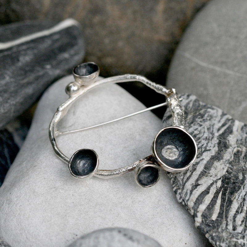 A handmade Sterling silver acorn brooch, inspired by the beauty of acorn cups on a ring of twig textured silver.