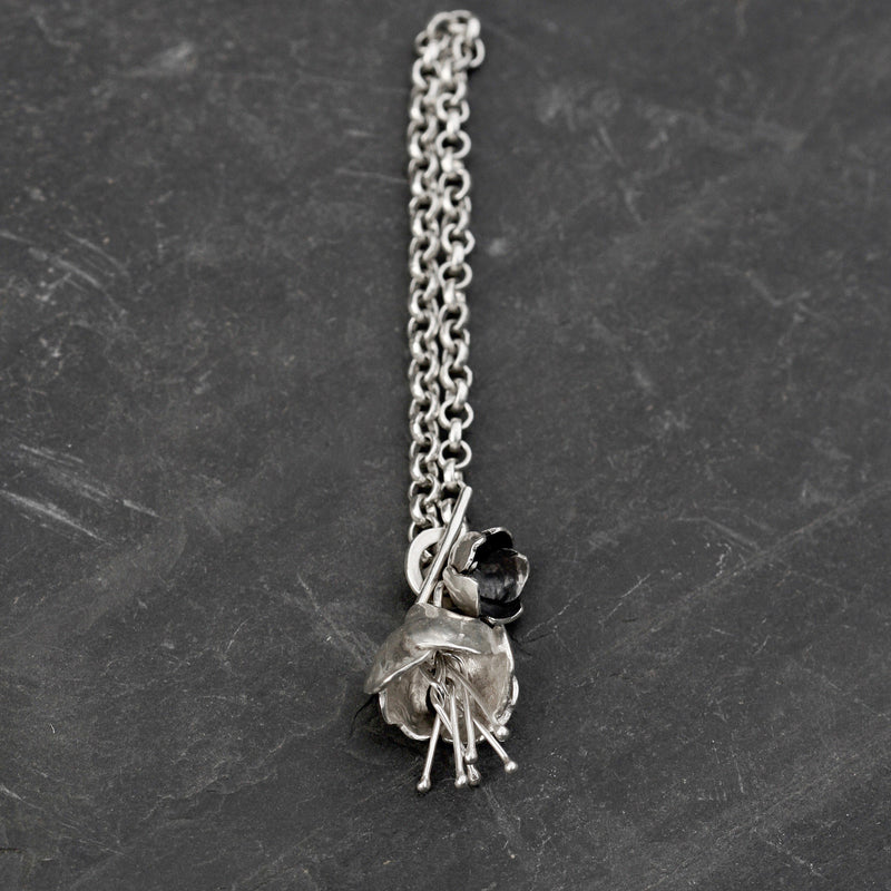 The Peony flower Bracelet is made in hallmarked Sterling silver with a fine belcher chain and a T bar catch with a peony and a oxidised buttercup. Silver floral jewellery handmade in England.