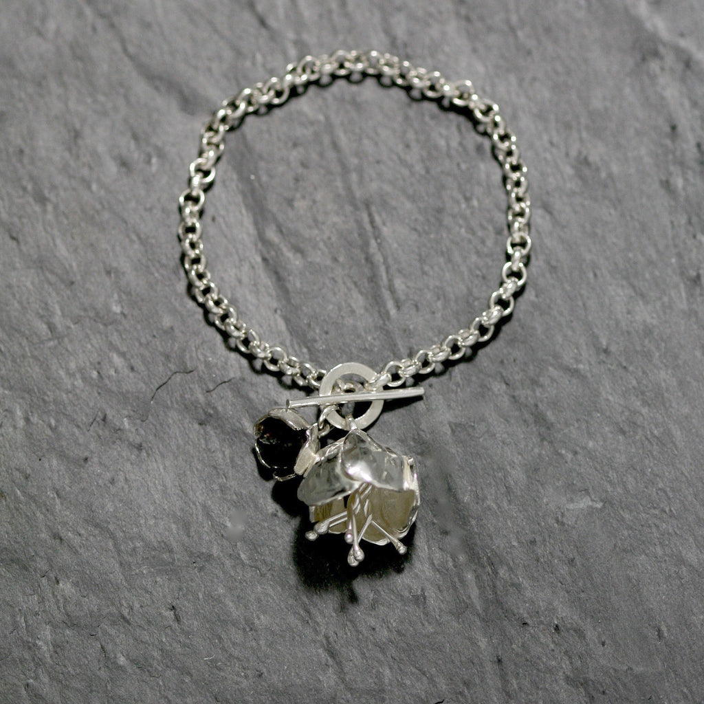 The Peony flower Bracelet is made in hallmarked Sterling silver with a fine belcher chain and a T bar catch with a peony and a oxidised buttercup. Silver floral jewellery handmade in England.