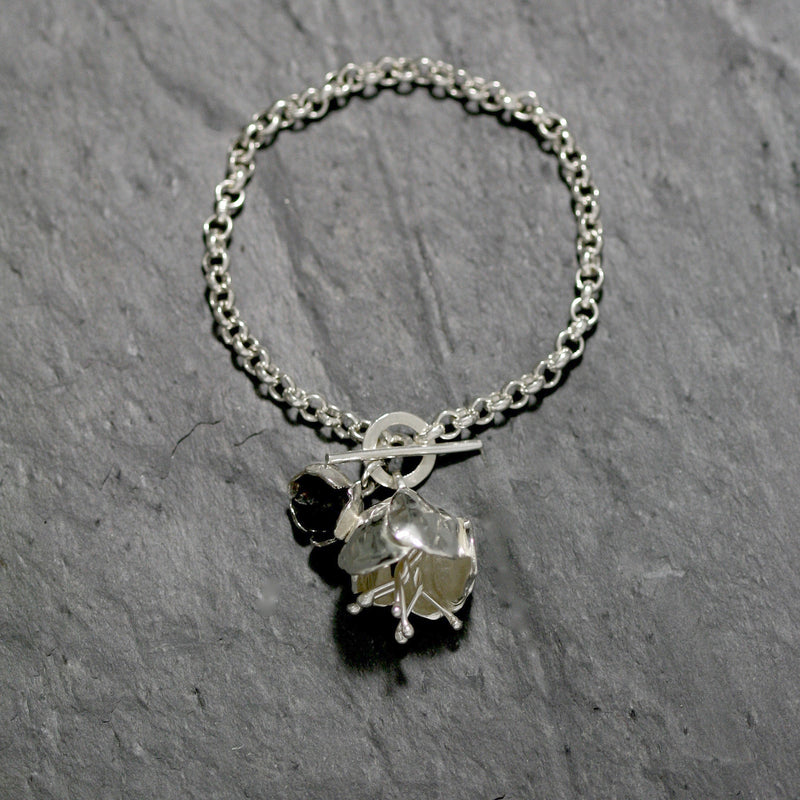 The Peony flower Bracelet is made in hallmarked Sterling silver with a fine belcher chain and a T bar catch with a peony and a oxidised buttercup. Silver floral jewellery handmade in England.