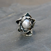 Hand carved Sterling silver rose ring with two layers of individually shaped rose petals, gently oxidised before a baroque pearl is carefully set and re-polished. Every piece is is a unique design. Floral jewellery handmade in England.