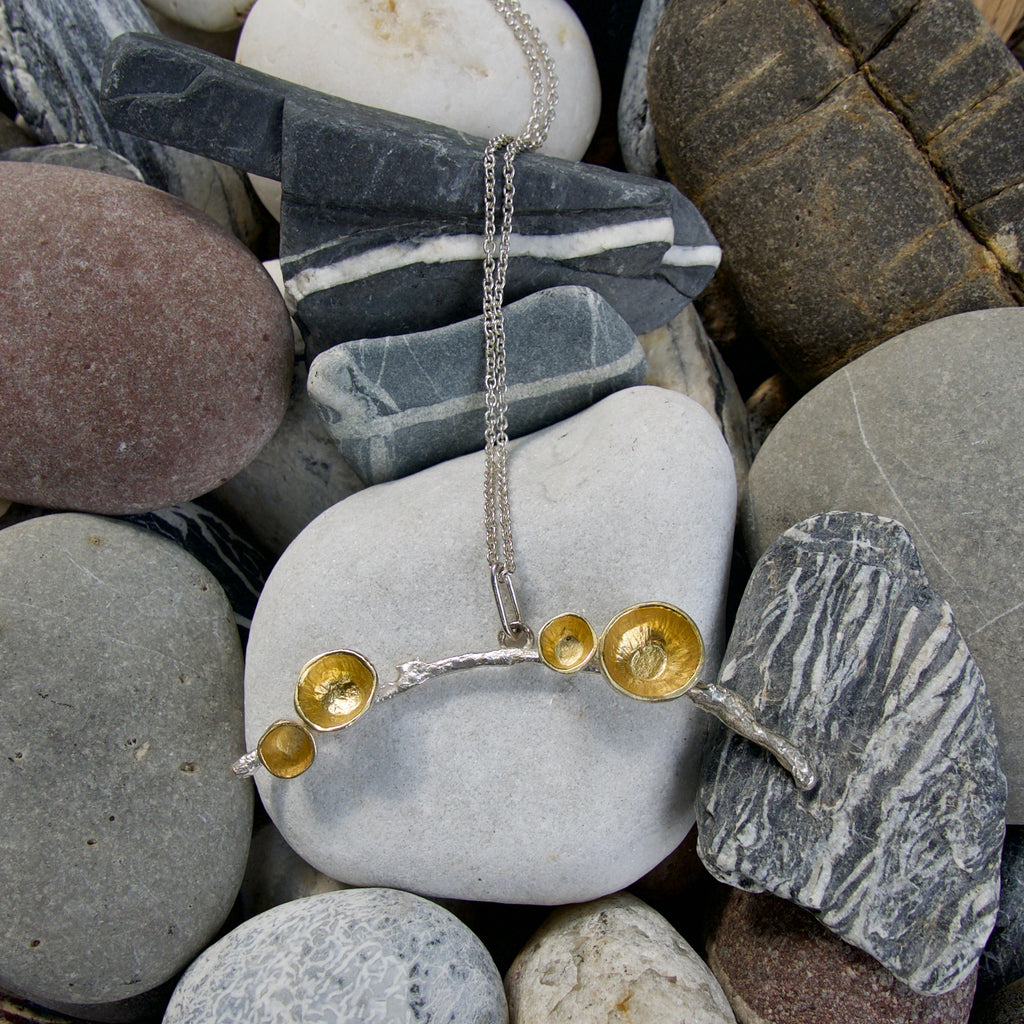 Handmade in Sterling silver my acorn necklace is strung on a 33 inch silver barleycorn chain. The pendant is 2 inches across and has three or four stylised acorn cups that can be gold plated, oxidised or polished silver.