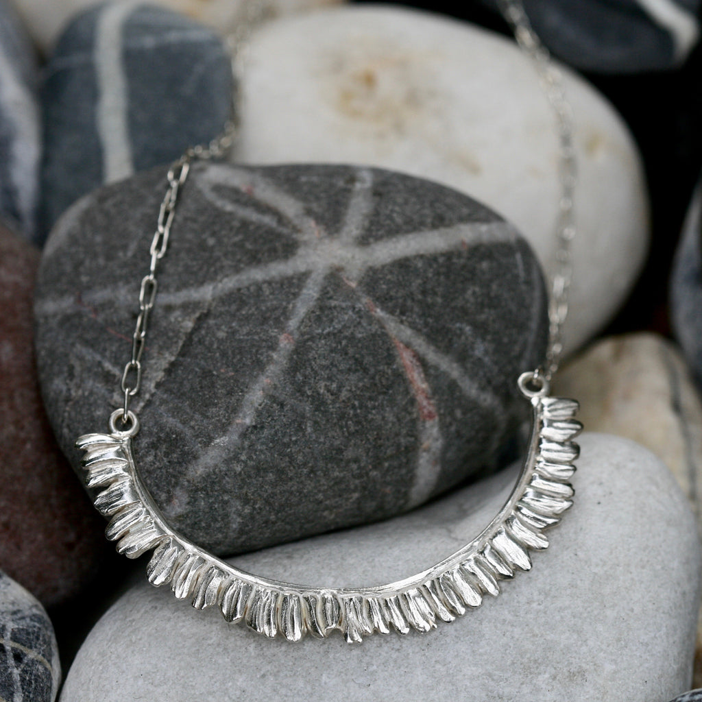 Half moon shaped Fern frond leaf necklace handmade in polished, hallmarked Sterling silver, measures nearly 4cm on an 18 inch hand tooled chain and a handmade hook. Botanical and leaf jewellery made in the UK.