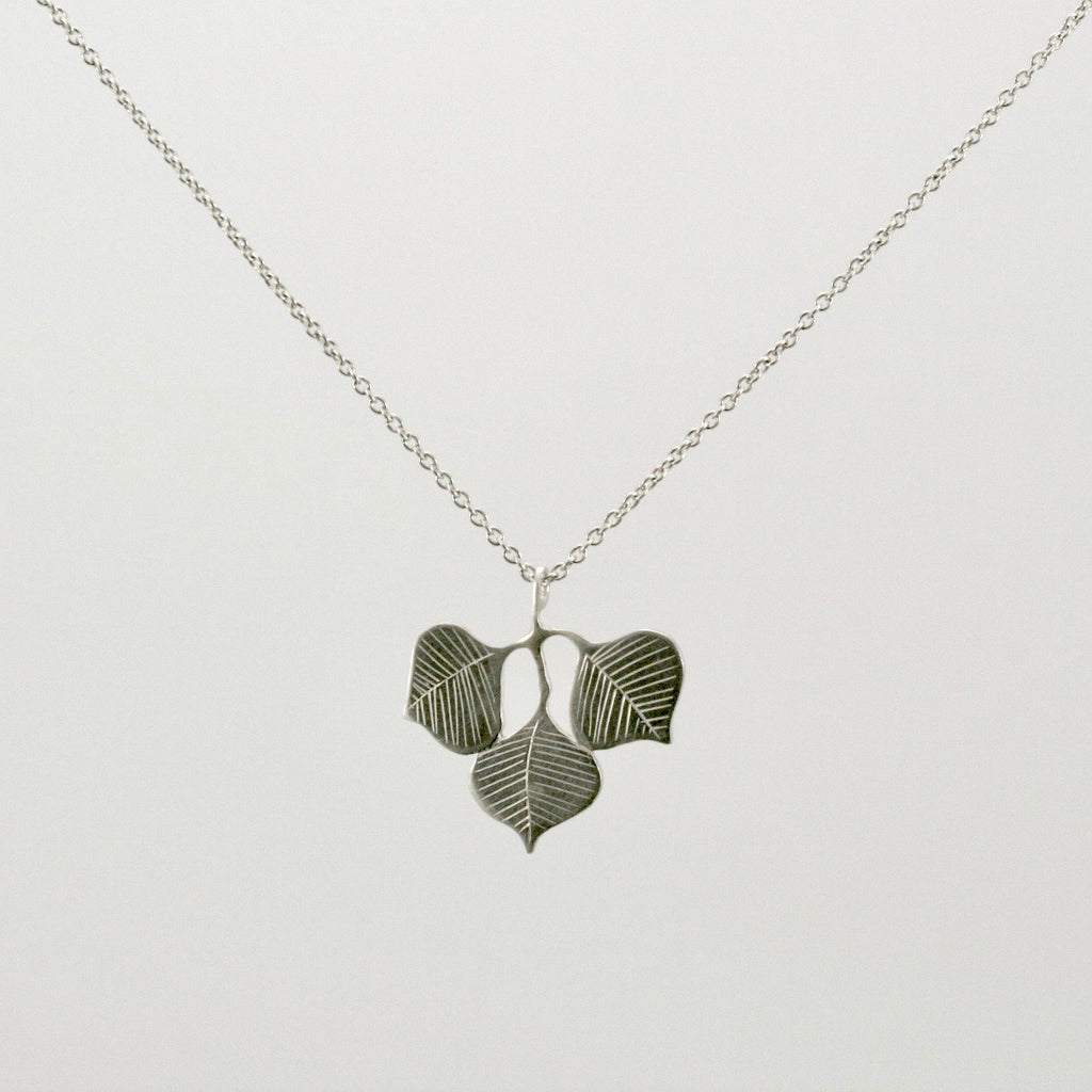 Three Sterling silver heart shaped Chinese tallow leaves make up this simple and elegant necklace. Botanical leaf jewellery. Available in polished silver or 18ct rose gold or 22ct yellow gold vermeil plate. On a 40 trace 18 inch silver chain.